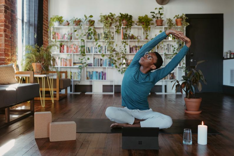 Outdoor Fitness Tech - a man is doing yoga in a living room