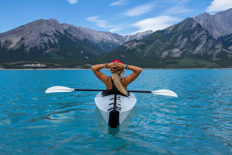 Kayaking Fitness - woman riding kayak at the middle of the sea