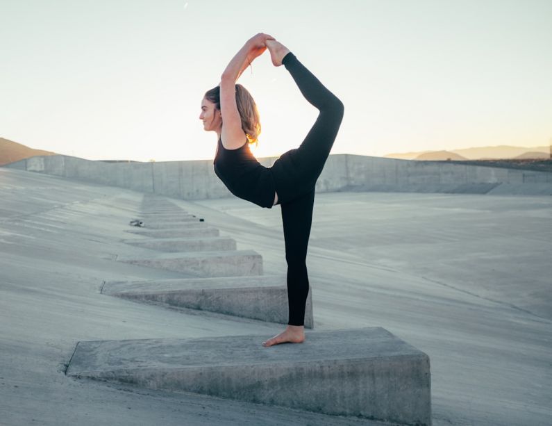 Flexibility Fitness - shallow focus photo of woman in black sleeveless shirt doing yoga