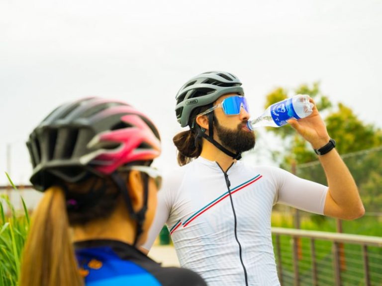 Hydration Fitness - a man with a beard drinking water from a bottle
